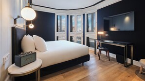 Un dormitorio moderno con una cama grande, un escritorio y un televisor.