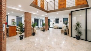 A spacious lobby with a high ceiling, a mezzanine level, and multiple seating areas. - Atrium Boutique Hotel (Tbilisi)