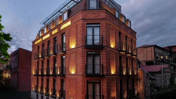 A multi-story hotel with a corner entrance, large windows, and a glass roof on the upper floor. - Atrium Boutique Hotel (Tbilisi)