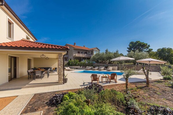 A residential property with a swimming pool, outdoor seating, and a garden. - Holiday house LUNA with pool (Bajčići)