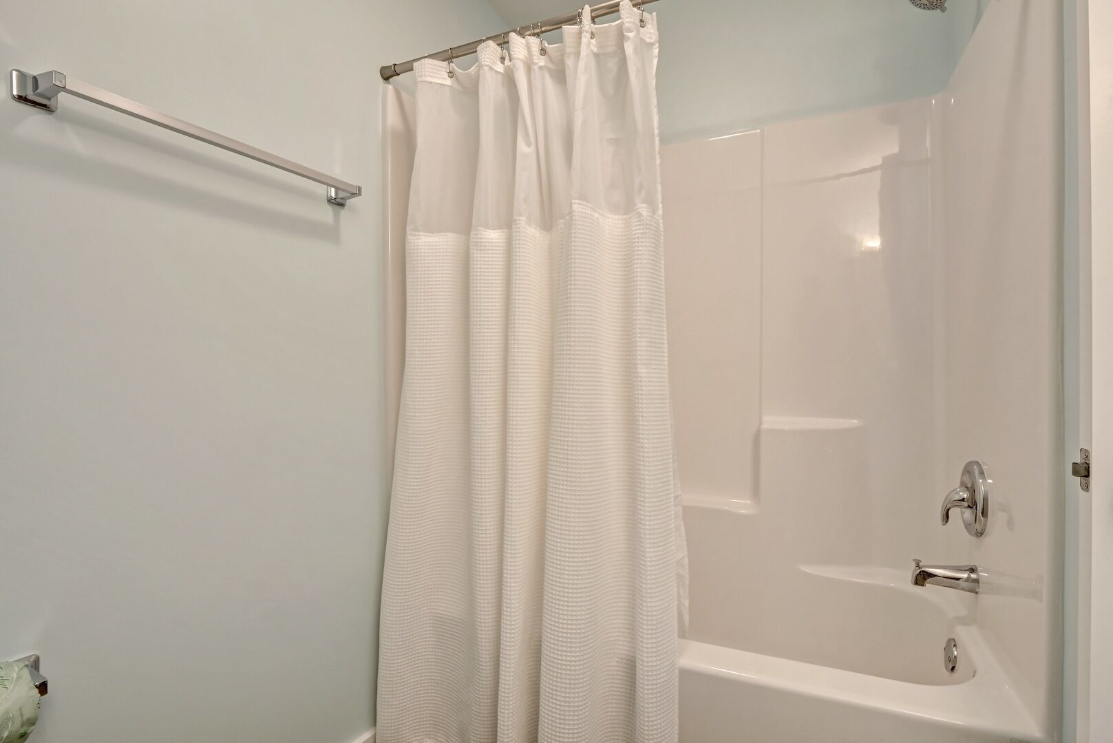 Une salle de bain moderne avec une douche à l’italienne, une baignoire et un porte-serviettes.