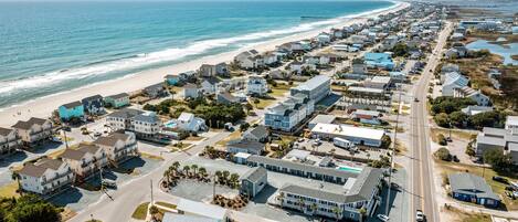 A coastal town with a beach, houses, and a pier.