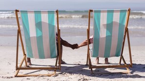 Two beach chairs with striped fabric facing the ocean. - Loggerhead Inn & Suites (Holly Ridge)