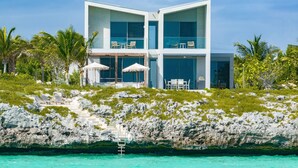 A modern two-story building with large windows, a pool, and outdoor seating. - South Bank (Providenciales)