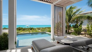 A modern outdoor lounge area with a pool, seating, and a view of the ocean. - South Bank (Providenciales)