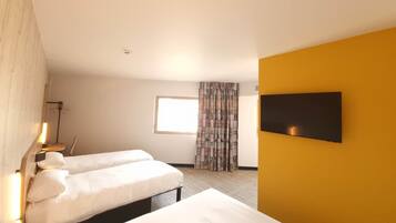 Een hotelkamer met twee bedden, een wandtelevisie en een raam met gordijnen.