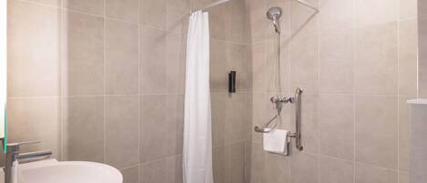 A modern bathroom with a shower, a sink, and a toilet.