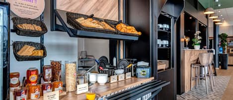 Un bufé de desayuno con diversos pasteles, panes y rellenos.