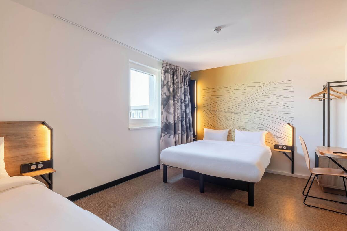 Une chambre d’hôtel avec un grand lit, des tables de chevet, un bureau et une chaise.