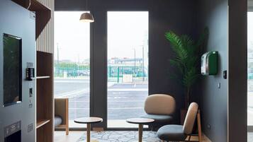 A modern interior with a seating area, a large window, and a plant.