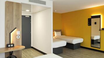 Een hotelkamer met een bed, nachtkastje en spiegel.