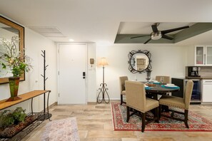 A dining area with a round table, chairs, a decorative mirror, and a ceiling fan. - CASA MERLOT-Anasazi Village-Ground floor beautiful condo steps away from Pool. (Phoenix)