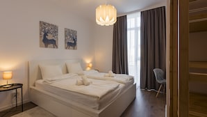 A modern bedroom with a large bed, bedside lamps, and artwork on the wall. - Zoe Apartment (Timisoara)