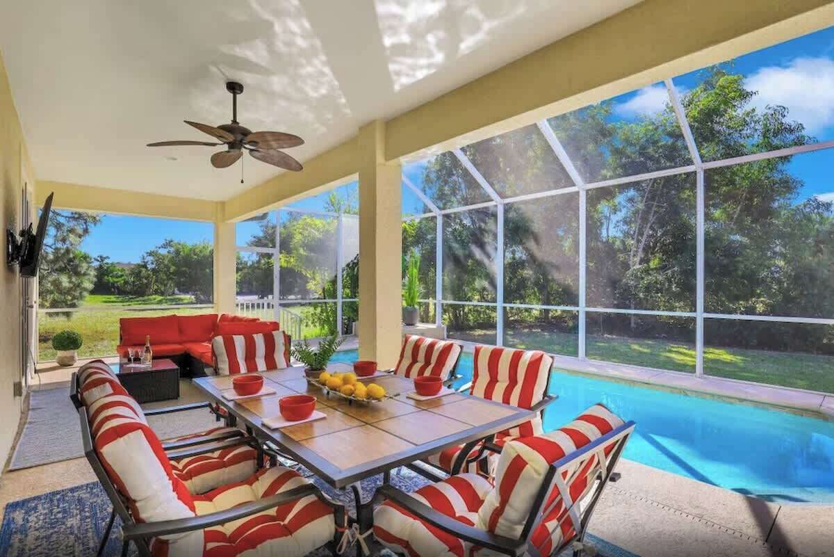 A sunlit room with a pool, large windows, and outdoor views.