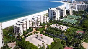 A coastal hotel complex with multiple high-rise buildings, a beach, and a sports court.