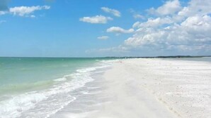 Une plage avec un ciel dégagé et des vagues douces.