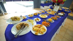 Una mesa de buffet con diversos alimentos y un letrero.