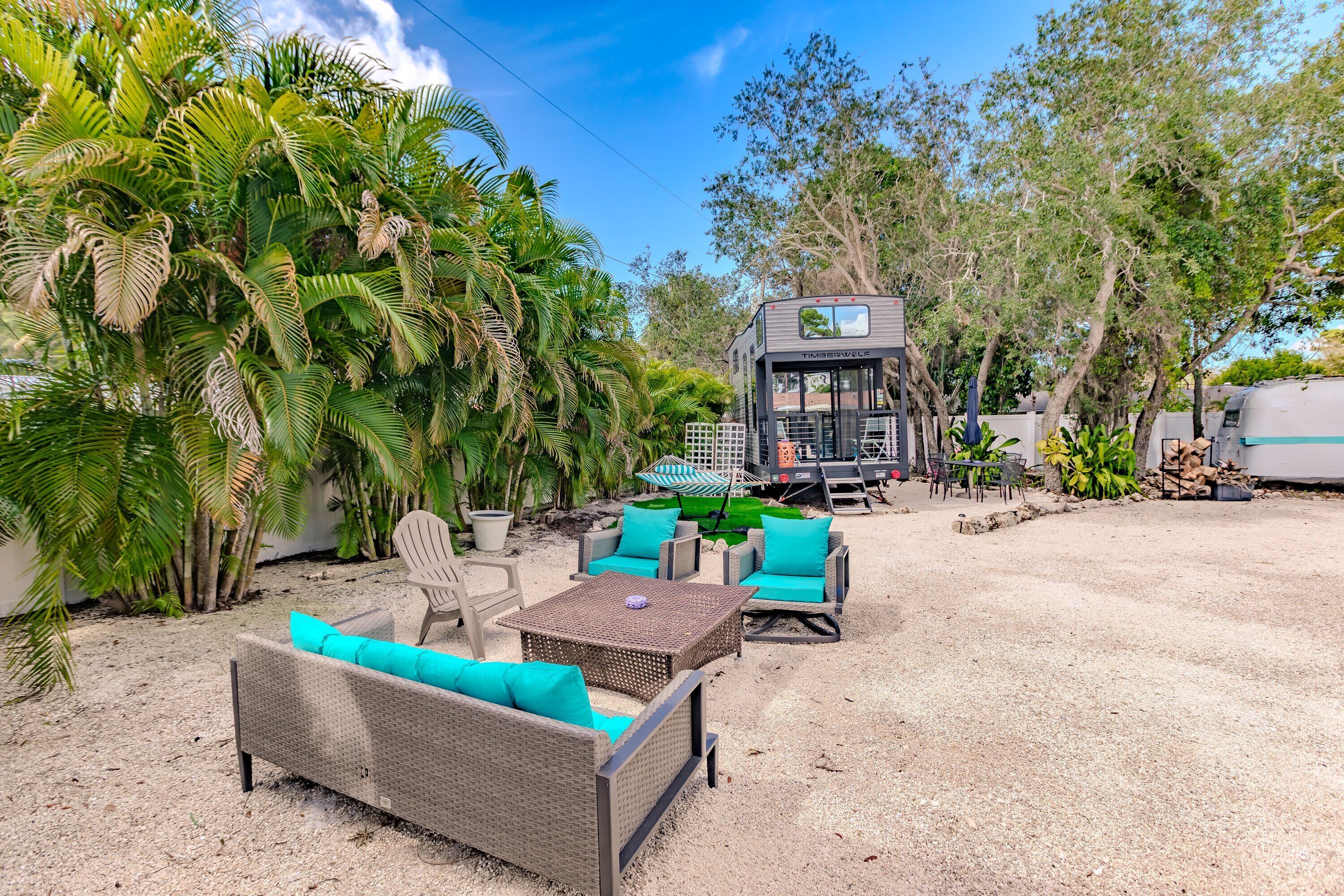 A recreational area with wicker furniture, a covered seating area, and a small building labeled "Timberview."
