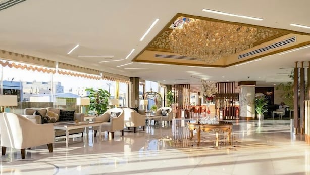 A spacious lobby with a high ceiling, a chandelier, and a coffee table. - Royal Boutique Hotel (Khamis Mushait)
