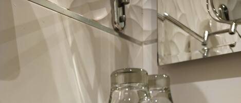 A bathroom vanity with a marble countertop, a wooden cabinet with two drawers, and a small round container.