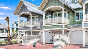 A row of two-story houses with balconies, white railings, and a garage. - Three-story townhouse with a balcony, two living areas, & a washer/dryer (Port Aransas)