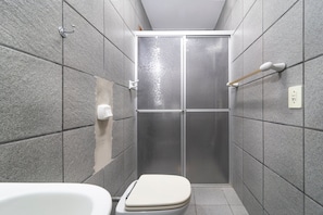A bathroom with a shower, toilet, and a towel rack.