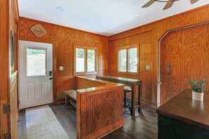 Un interior de madera con un banco, una puerta y ventanas.