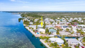 A coastal resort with multiple buildings, a marina, and clear blue waters. - Beautiful Open-Water Property (Big Pine Key)
