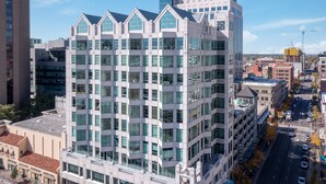 Un edificio de varios pisos con un diseño arquitectónico moderno, que cuenta con grandes ventanales y un llamativo letrero de Zions Bank en la parte superior.