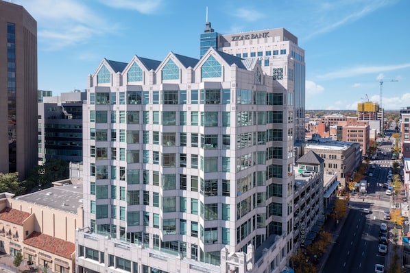 A multi-story building with a modern architectural design, featuring large windows and a prominent Zions Bank sign on the top.