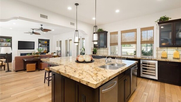 A modern kitchen with a large island, dark cabinetry, and pendant lighting. - Pet Friendly Beautiful PGA West Spanish Style Home Private Oasis Beautiful Pool (La Quinta)