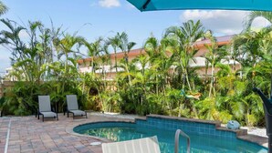 A pool area with lounge chairs and a tiki statue.