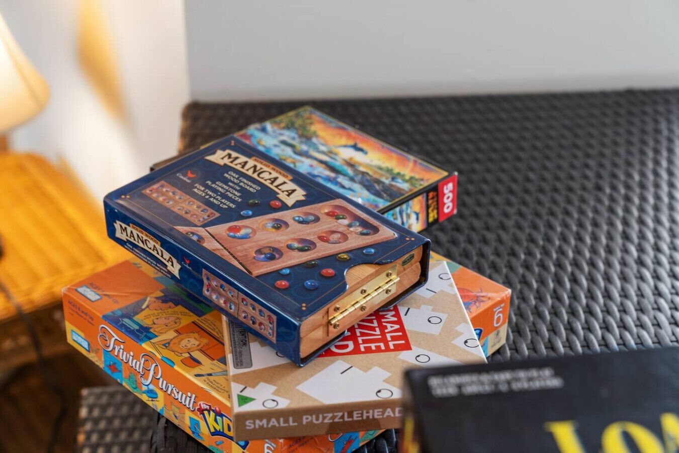 Une pile de boîtes de jeux de réflexion, dont un jeu de Mancala et un petit casse-tête.