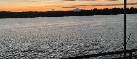 A view from a covered area overlooking a body of water with a distant mountain silhouette.