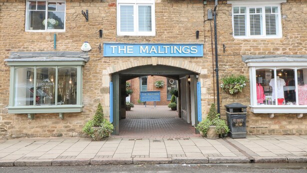 Un edificio de piedra con un letrero que dice THE MALTINGS.