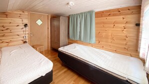 Une petite pièce agréable, dotée d’un lit, d’un canapé-lit, d’un petit tabouret et d’une armoire.