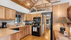 A kitchen with wooden cabinets, a microwave, a stove, and a dishwasher.