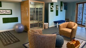A room with a wooden cabinet, a blue bench, a brown armchair, a blue exercise ball, and a wooden rack. - Breathtaking mountain views-4king en suites, bunk rm, sauna, air hockey,MANCAVE! (Hot Springs Village)