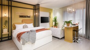 A modern bedroom with a bed, bedside tables, a desk with chairs, a TV, and potted plants. - Prime Select Kattameya Bavaria (Cairo)