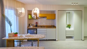A modern kitchen with white cabinets, a granite countertop, and a built-in dishwasher. There are two pendant lights and a small potted plant on the counter. - Prime Select Kattameya Bavaria (Cairo)
