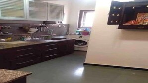 Uma cozinha com pia, armários e máquina de lavar.
