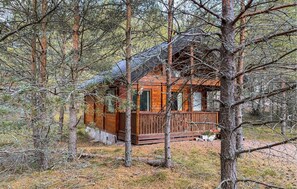 A cabin surrounded by trees, with a wooden deck and a covered porch. - Pet friendly home in Nybro with sauna (Nybro)