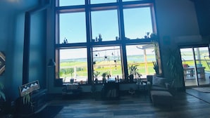 A spacious room with large windows overlooking a scenic landscape, a cozy seating area with a coffee table, and a fireplace.