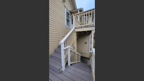 A wooden staircase leading to a balcony with a railing. - Spacious 2 bedroom historic home with two king beds and kitchenette. (Ashland)