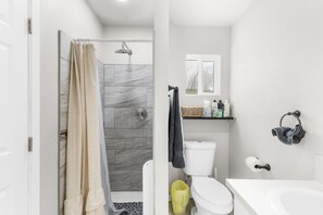 A modern bathroom with a shower, toilet, and bathtub.
