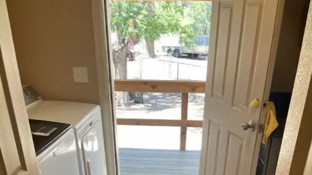A narrow hallway with a wooden floor leading to a door with a view of a street outside. - Enjoy living on a pecan orchard surrounded by trees!!!!!!
 (Las Cruces)