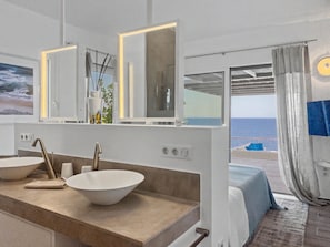 Un baño con dos lavamanos, un espejo y vistas al mar.