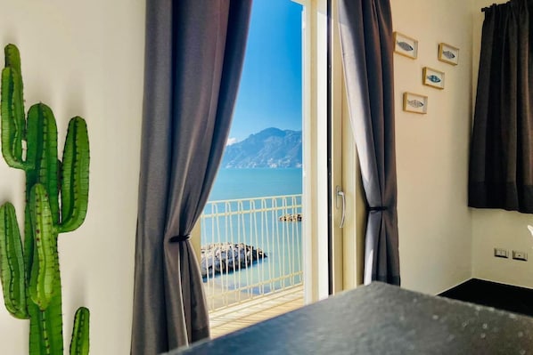 Una habitación con vistas al mar, un cactus y cuadros en la pared.