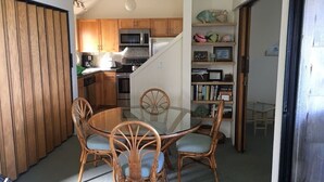 A compact kitchen with wooden cabinets, a microwave, and a stove. - Sealodge J7 - 2BR/2BA, 2nd Floor Prime End Unit, Spectacular Oceanfront Views (Princeville)