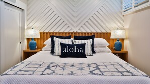 A hotel room with a bed, two nightstands, a ceiling fan, and a vent.